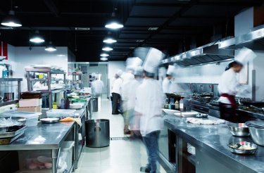 Uomini con cappelli da chef in una cucina di ristorante