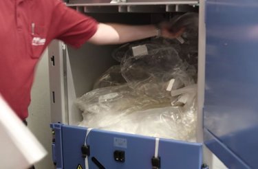 Operatore che carica rifiuti in plastica nella pressa A305 Mil-tek