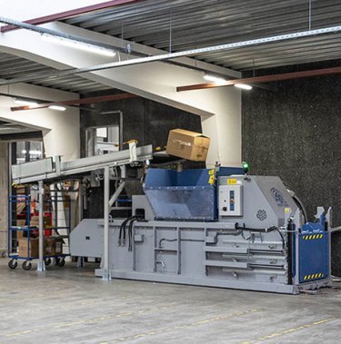 Pressa a balle Mil-tek con nastro trasportatore automatico per il compattamento del cartone presso CreativCompany.