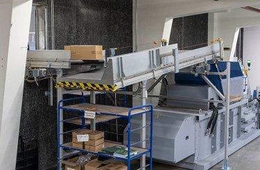 Vista ravvicinata del nastro trasportatore inclinato collegato alla pressa a balle Mil-tek presso CreativCompany