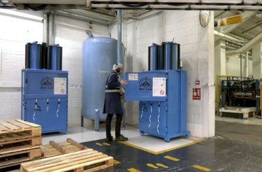 Un operatore utilizza le presse a balle Mil-tek presso Trivium Packaging, con serbatoio d'aria compressa al centro