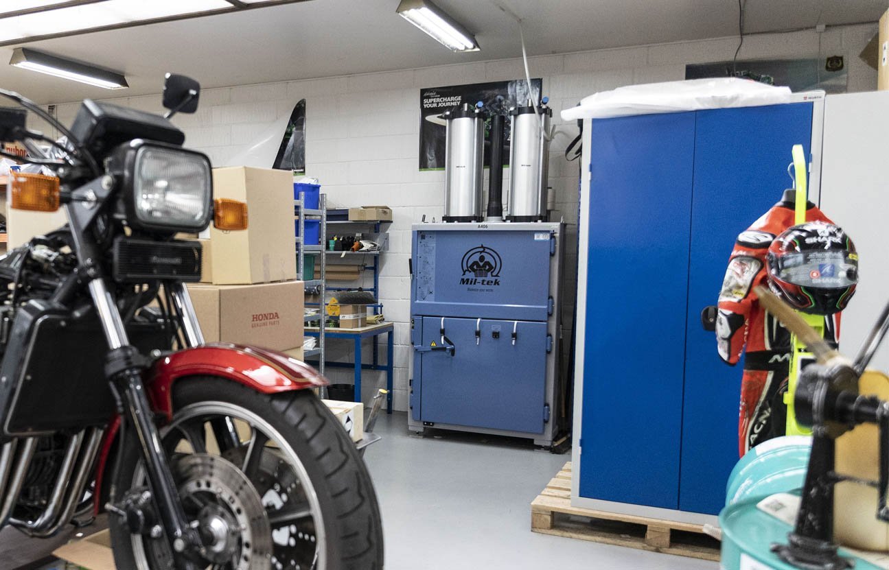 Vista generale del magazzino di Skjern Motorcycles con la pressa a balle Mil-tek A406, una motocicletta Kawasaki e attrezzature da moto